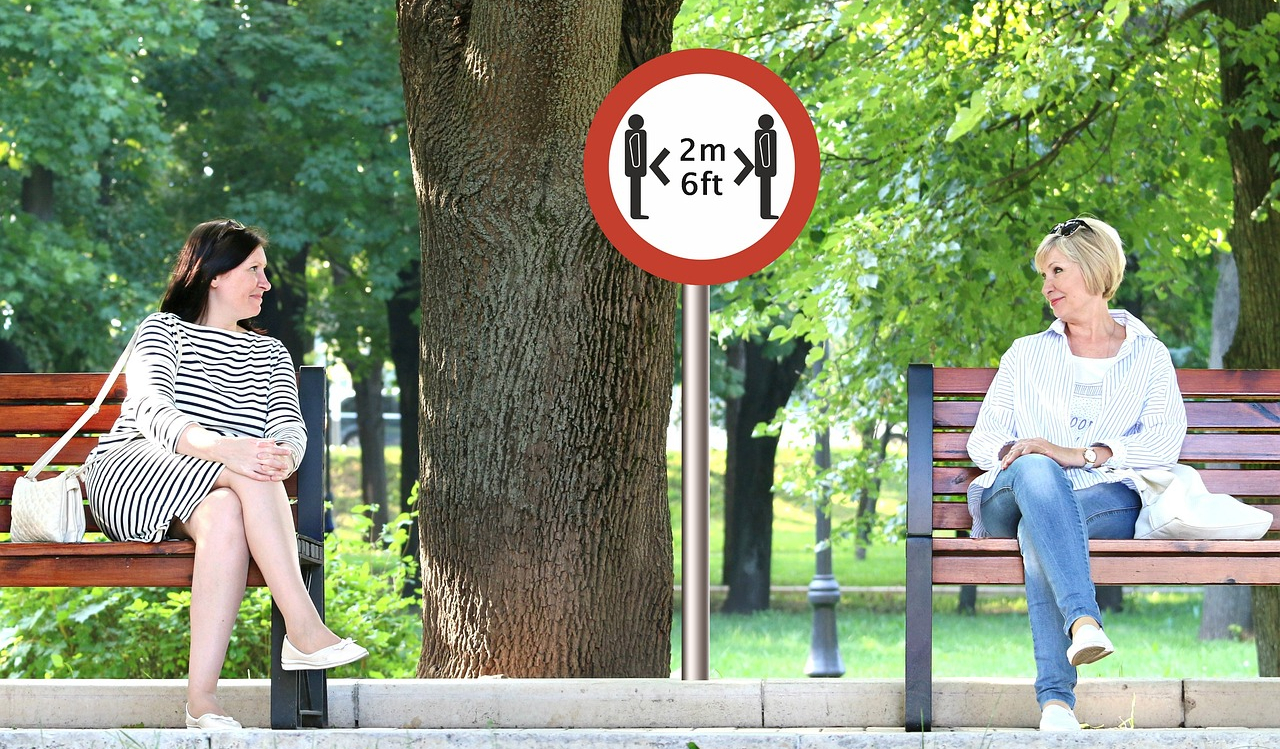 two women sat outside 6 feet apart - staying safe during theCOVID 19 Pandemic